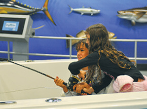Kids enjoying the fishing and boating simulator at Go Fish Education Center in Byron Georgia